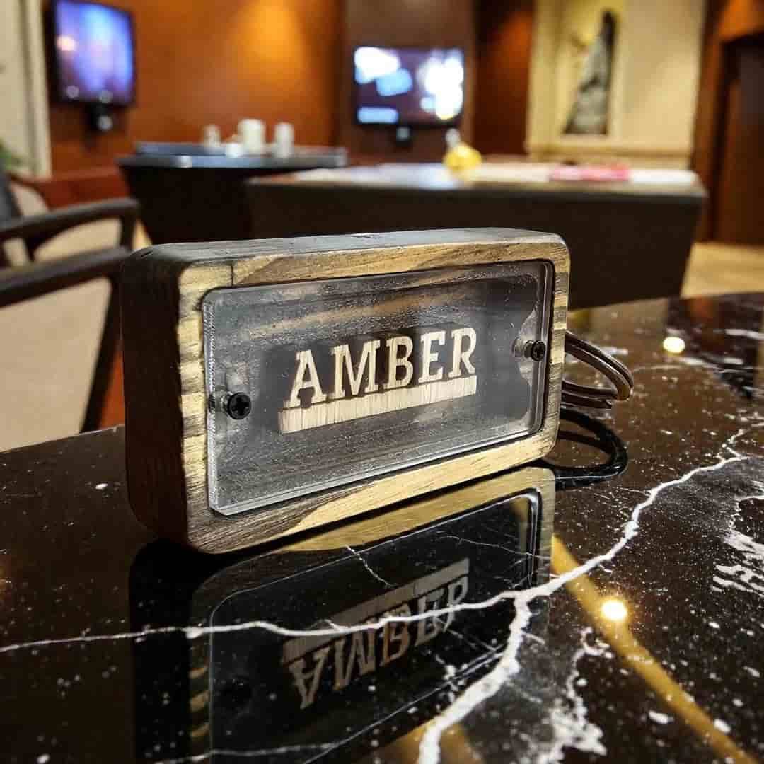 Butik otel resepsiyonunda mermer bankoda duran Amber oda isimli ahşap otel anahtarlığı
